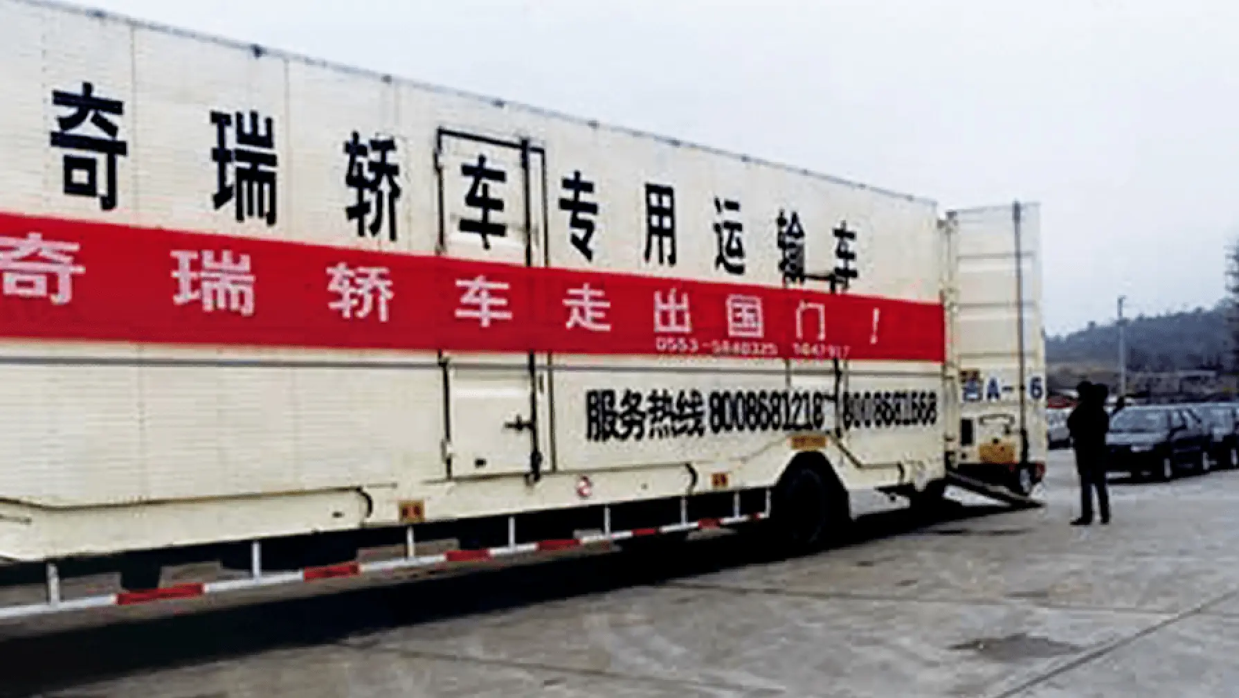 Erster Chery Fahrzeugexport 2001 - historischer LKW-Transport mit chinesischer Beschriftung markiert den Beginn der globalen Expansion